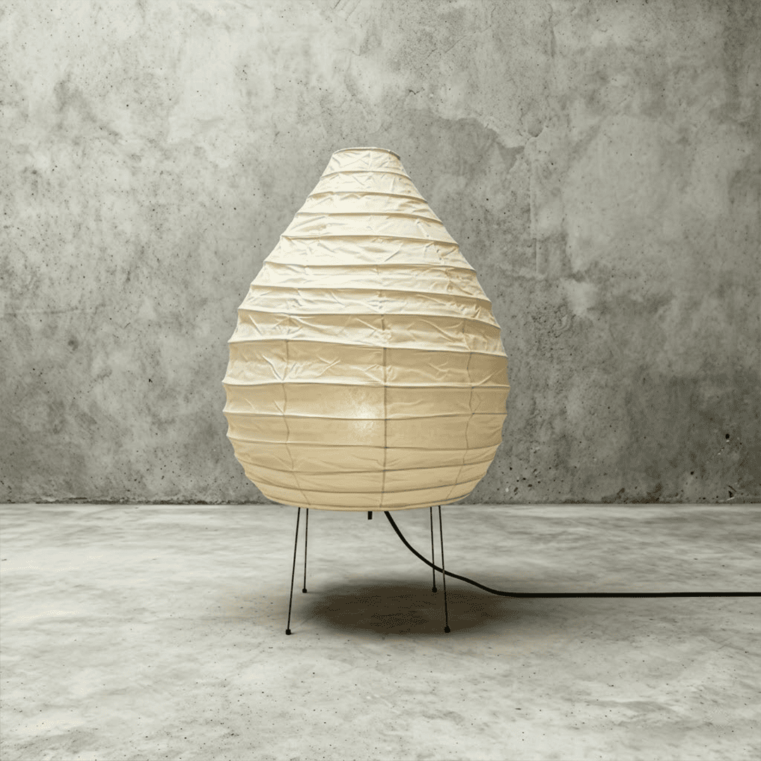 Large 22N Washi paper table lamp with bamboo ribs, glowing warmly on a minimalist floor setting.