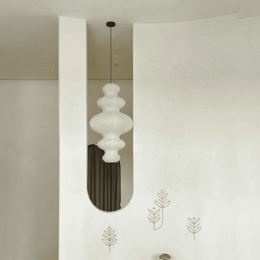 Large Akari Juni washi paper pendant lamp glowing in a minimalist Japandi living room with warm 3000K light.