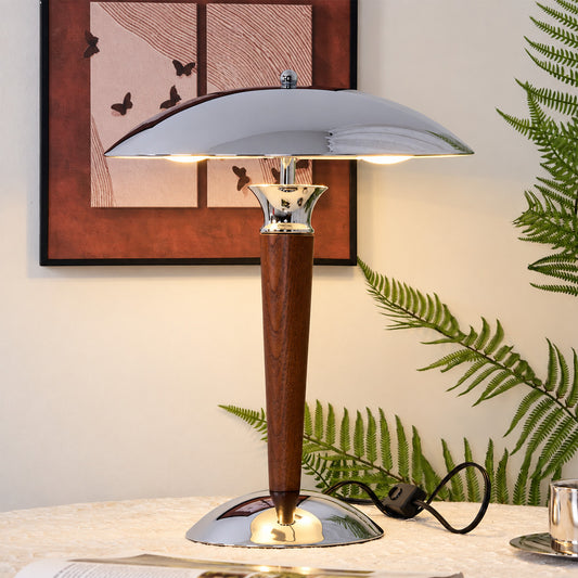 Casco chrome and walnut table lamp providing warm focused light on a home office desk