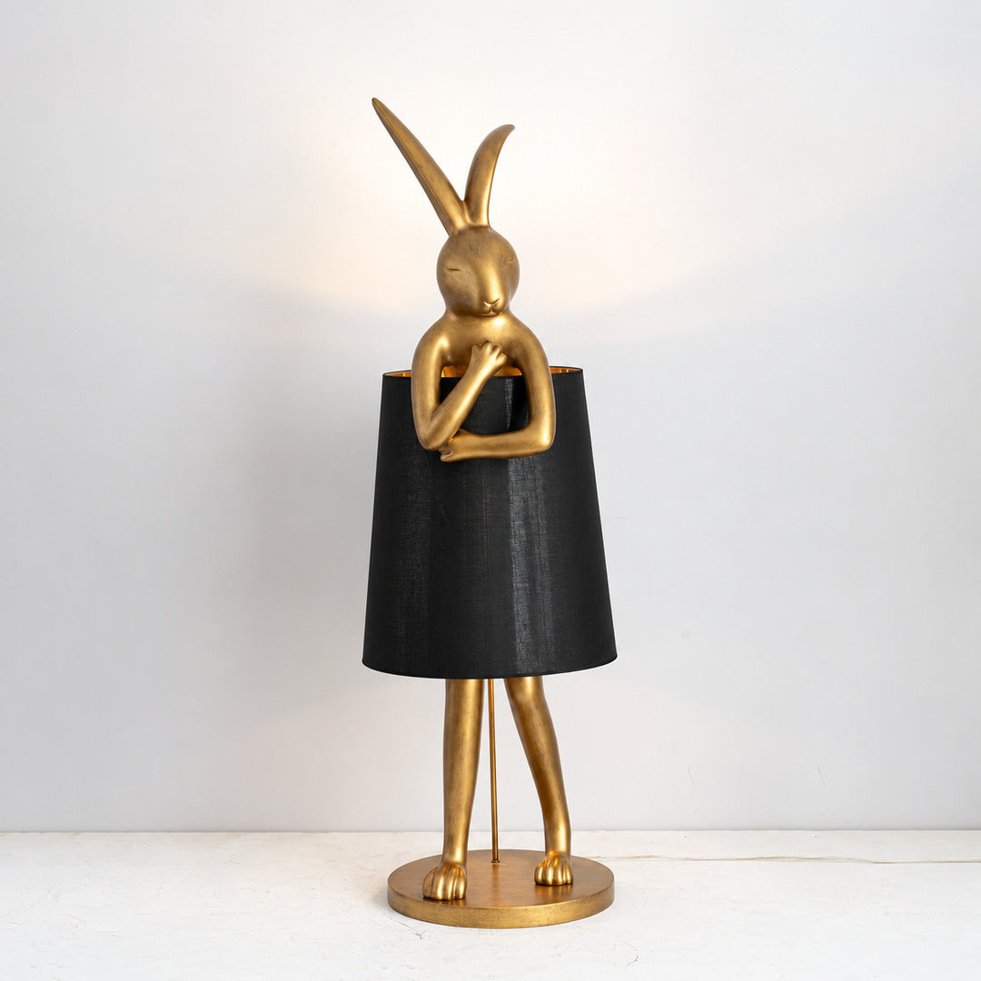 Vintage gold Hare silhouette table lamp with a black shade as a bold accent on a shelf