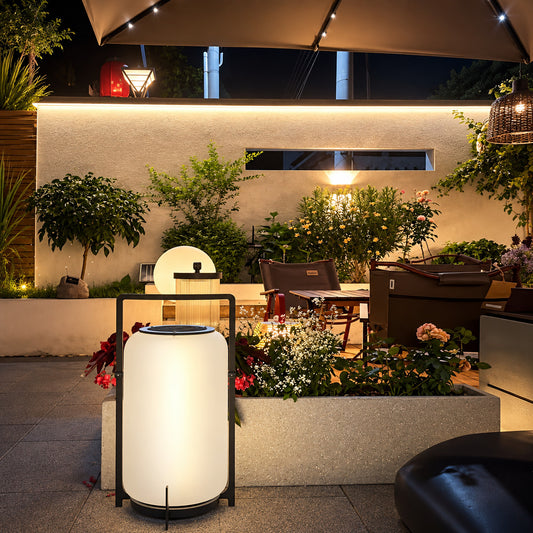 Lucciola rechargeable lantern lighting a garden seating area with a soft warm glow