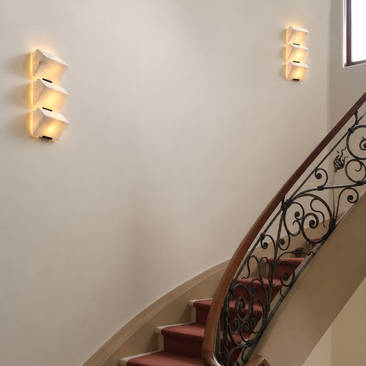 Scala alabaster wall sconce lighting a staircase wall with a soft stepped natural-stone glow