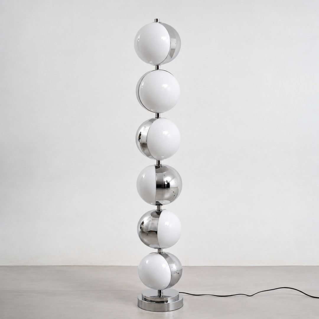 Slancio chrome floor lamp standing in a living room corner with a warm minimalist glow