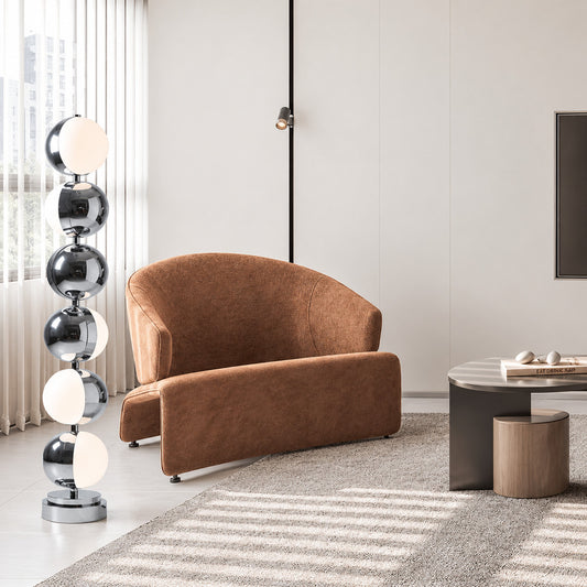 Slancio chrome floor lamp standing beside a sofa as a sleek minimalist accent