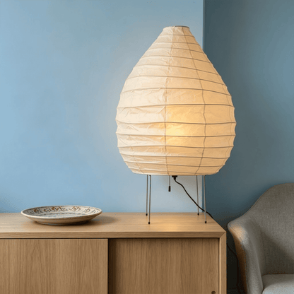 Large 22N Washi paper table lamp with bamboo ribs, glowing warmly on a minimalist floor setting.