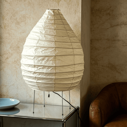 Large 22N Washi paper table lamp with bamboo ribs, glowing warmly on a minimalist floor setting.