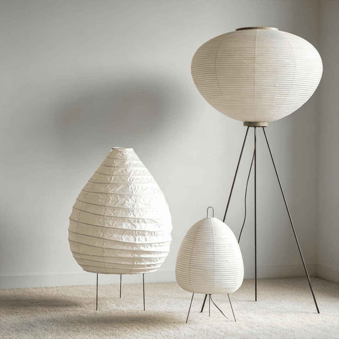 Large 22N Washi paper table lamp with bamboo ribs, glowing warmly on a minimalist floor setting.