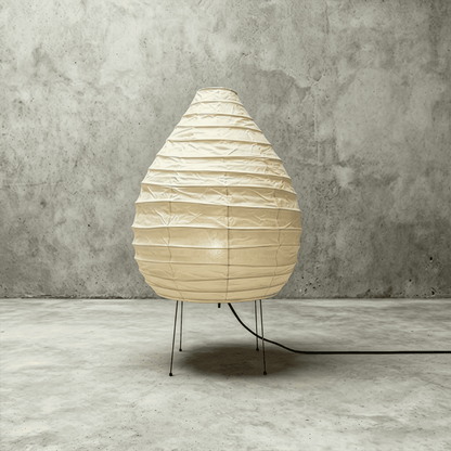 Large 22N Washi paper table lamp with bamboo ribs, glowing warmly on a minimalist floor setting.