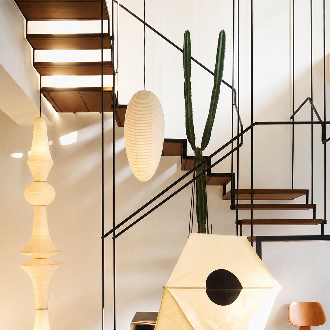 23A 24A washi paper egg shape pendant light hanging in a high ceiling staircase area with modern art decor