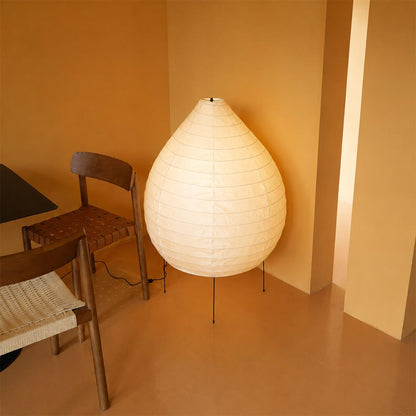 Warm ambient lighting from a 23N washi paper pear shape sculptural floor lamp in a cozy modern interior corner