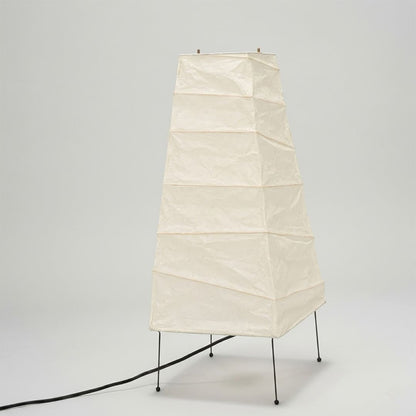 Handcrafted organic oval Washi Paper 4N Table Lamp on black tripod legs emitting a soft warm glow in a Japandi style interior setting.