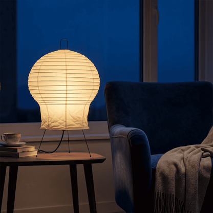 Akari 2N Table Lamp handmade with mulberry paper on a minimalist tripod stand, warm light glowing through textured washi paper.