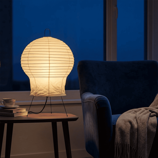 Akari 2N Table Lamp handmade with mulberry paper on a minimalist tripod stand, warm light glowing through textured washi paper.