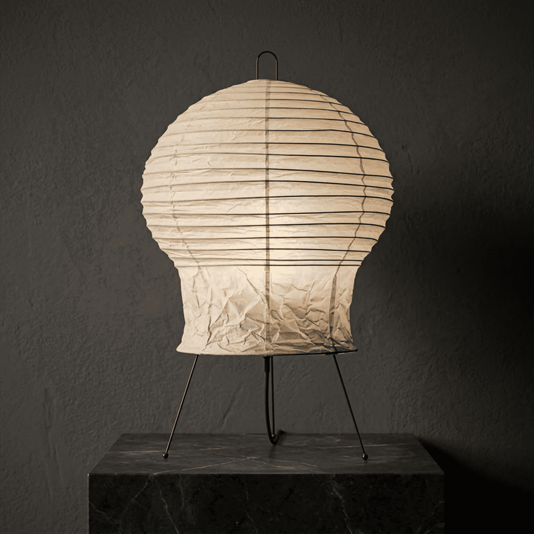 Akari 2N Table Lamp handmade with mulberry paper on a minimalist tripod stand, warm light glowing through textured washi paper.