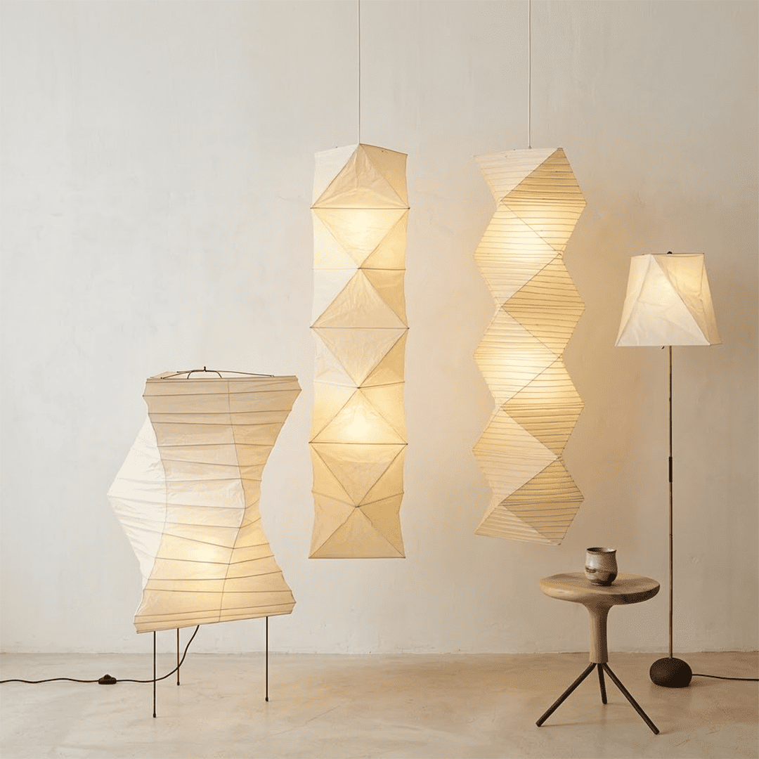 Large Akari L8 style vertical washi paper pendant light, 63 inches tall with accordion folds, emitting a warm ethereal glow.
