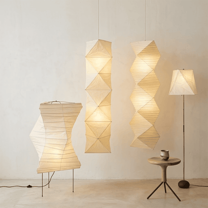 Large Akari L8 style vertical washi paper pendant light, 63 inches tall with accordion folds, emitting a warm ethereal glow.