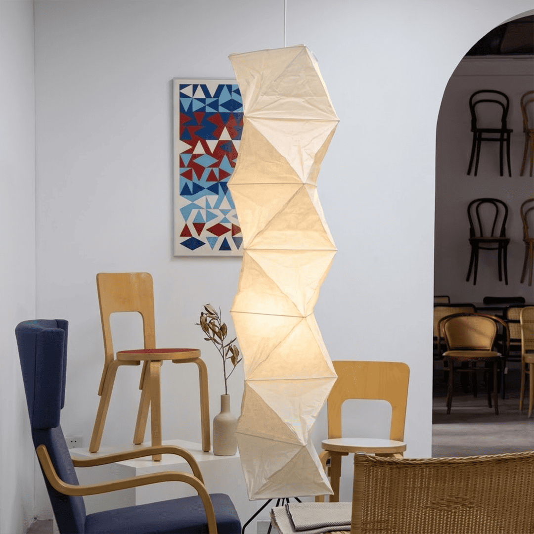 Large Akari L8 style vertical washi paper pendant light, 63 inches tall with accordion folds, emitting a warm ethereal glow.