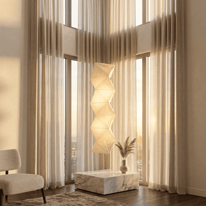 Large Akari L8 style vertical washi paper pendant light, 63 inches tall with accordion folds, emitting a warm ethereal glow.