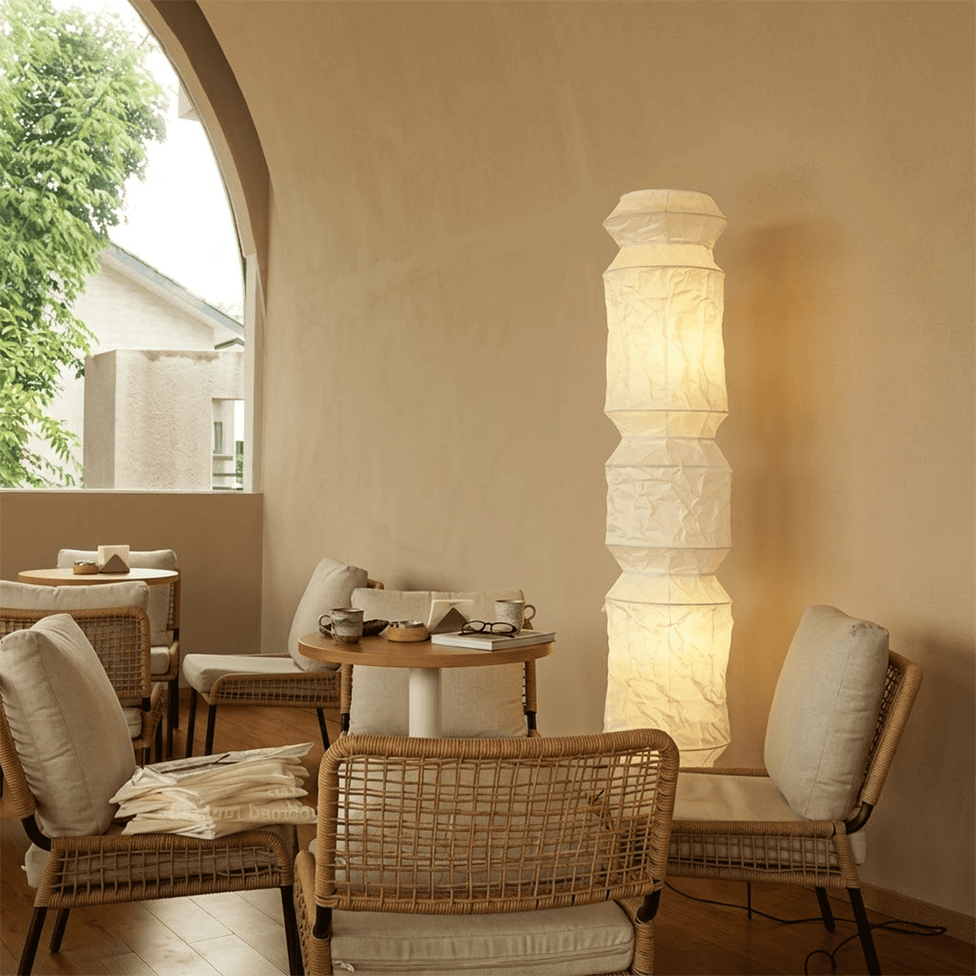 Minimalist modern home lamp: A sculptural Japanese-style multi-tiered paper floor lamp with a columnar design, providing warm interior decoration lighting for a cozy atmosphere.