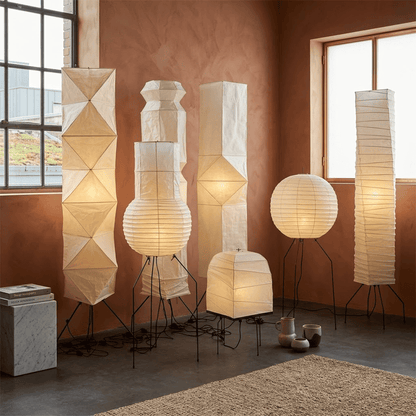 Minimalist modern home lamp: A sculptural Japanese-style multi-tiered paper floor lamp with a columnar design, providing warm interior decoration lighting for a cozy atmosphere.
