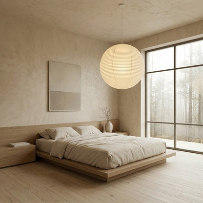 Large Washi paper sphere pendant light hanging in a minimalist Japandi style bedroom with warm light.