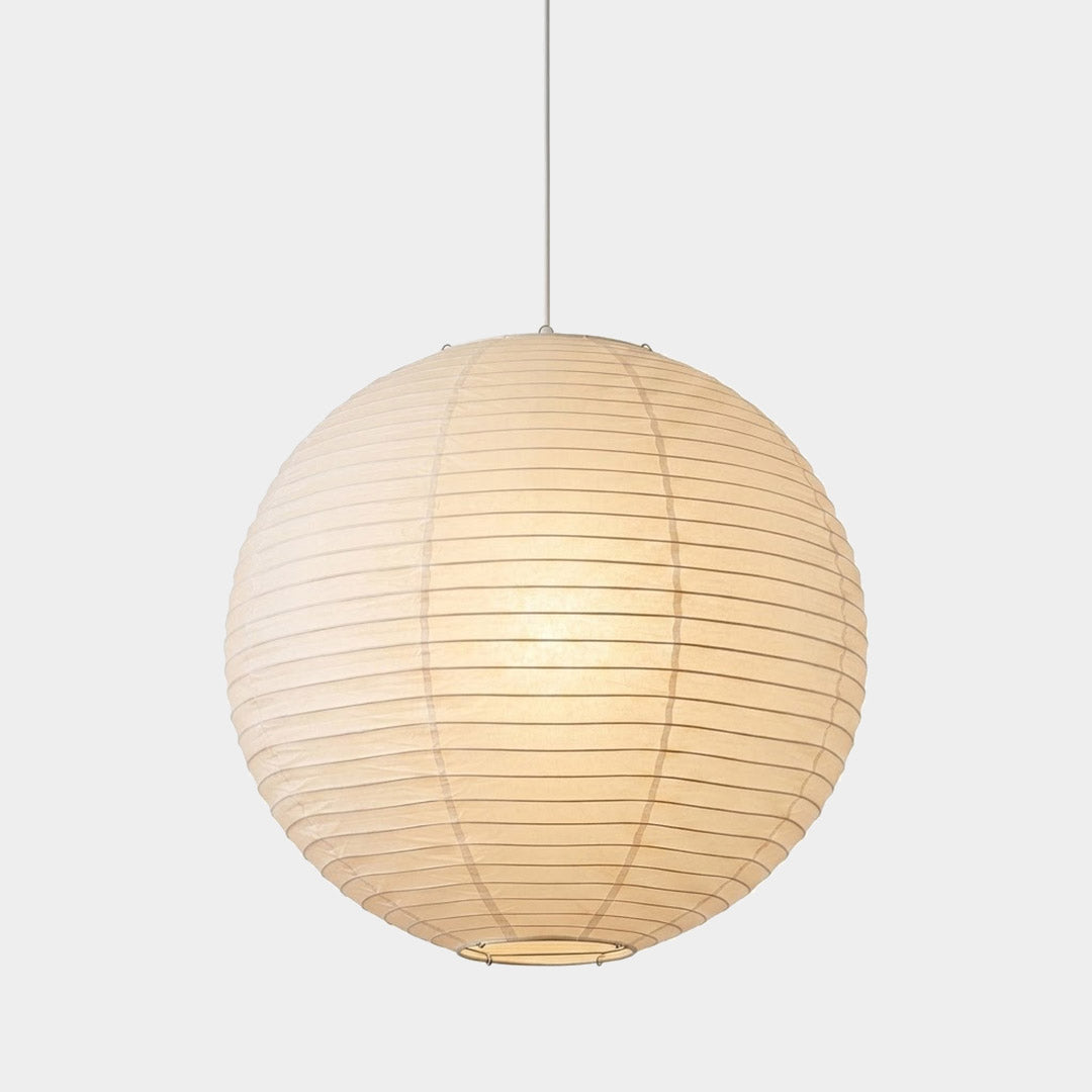 Large Washi paper sphere pendant light hanging in a minimalist Japandi style bedroom with warm light.