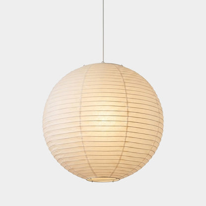 Large Washi paper sphere pendant light hanging in a minimalist Japandi style bedroom with warm light.