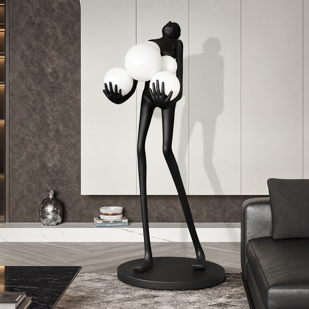 Abbraccio glass floor lamp standing beside a sofa as a sculptural centerpiece in a living room