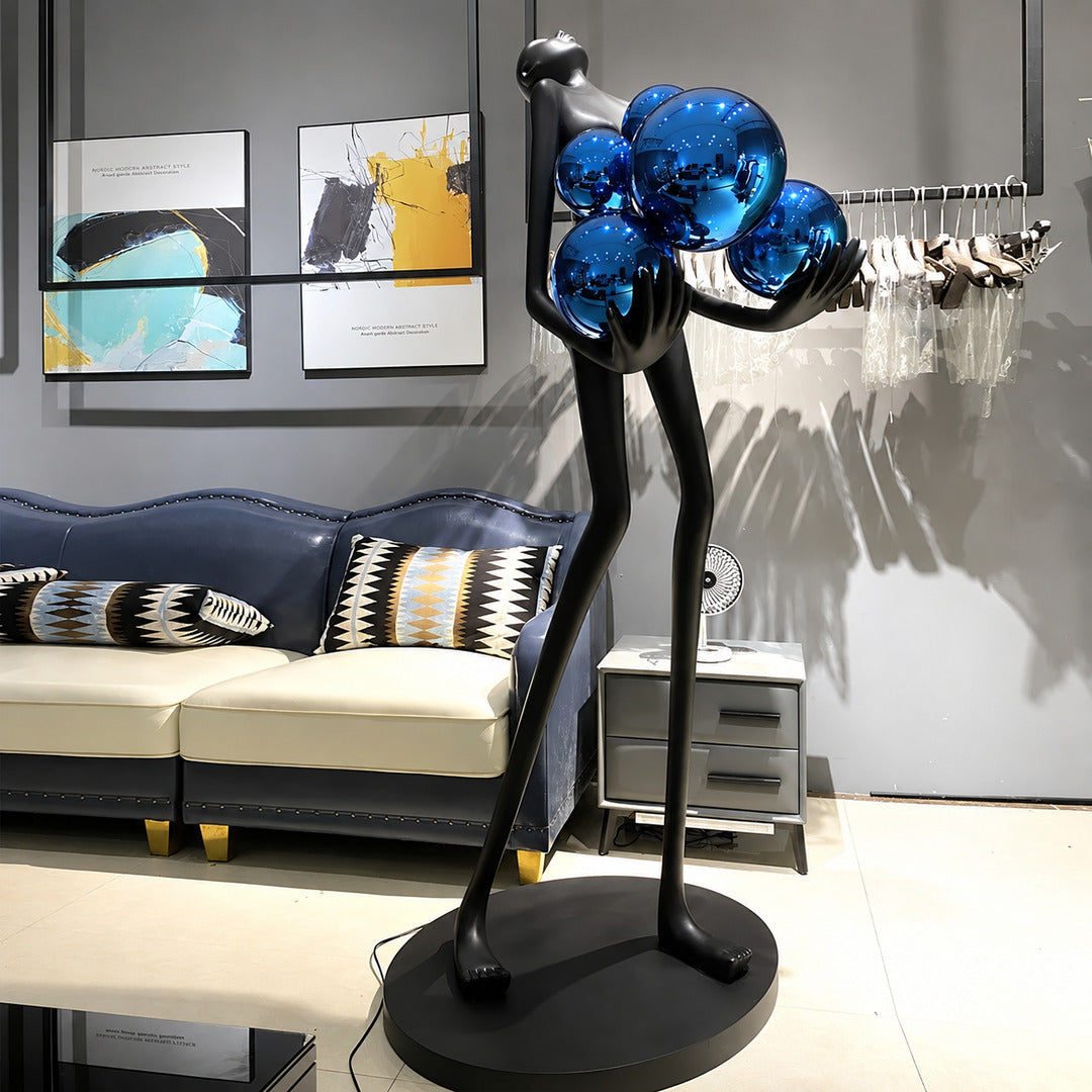 Abbraccio glass floor lamp standing beside a sofa as a sculptural centerpiece in a living room