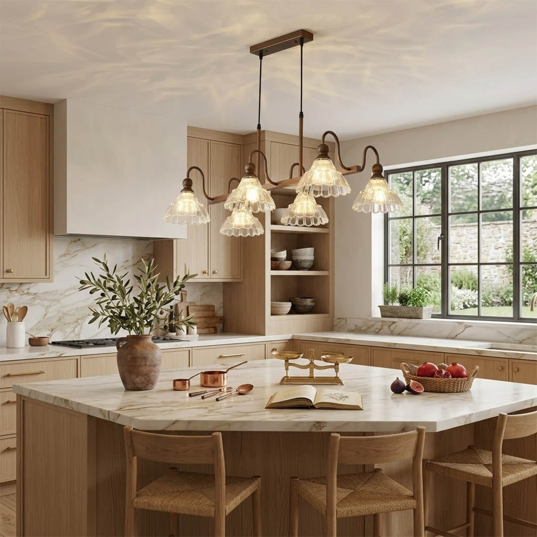 Adele linear antique brass chandelier above modern kitchen island vintage flower glass shades warm welcoming statement piece