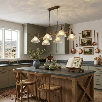 Adele linear antique brass chandelier above modern kitchen island vintage flower glass shades warm welcoming statement piece