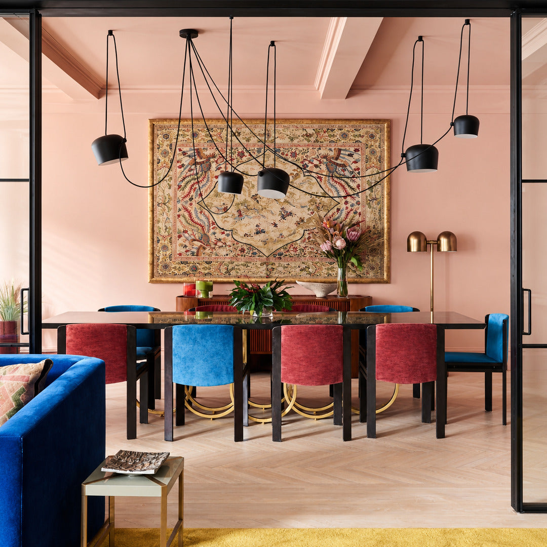 Aim pendant light casting adjustable warm light over a contemporary dining table