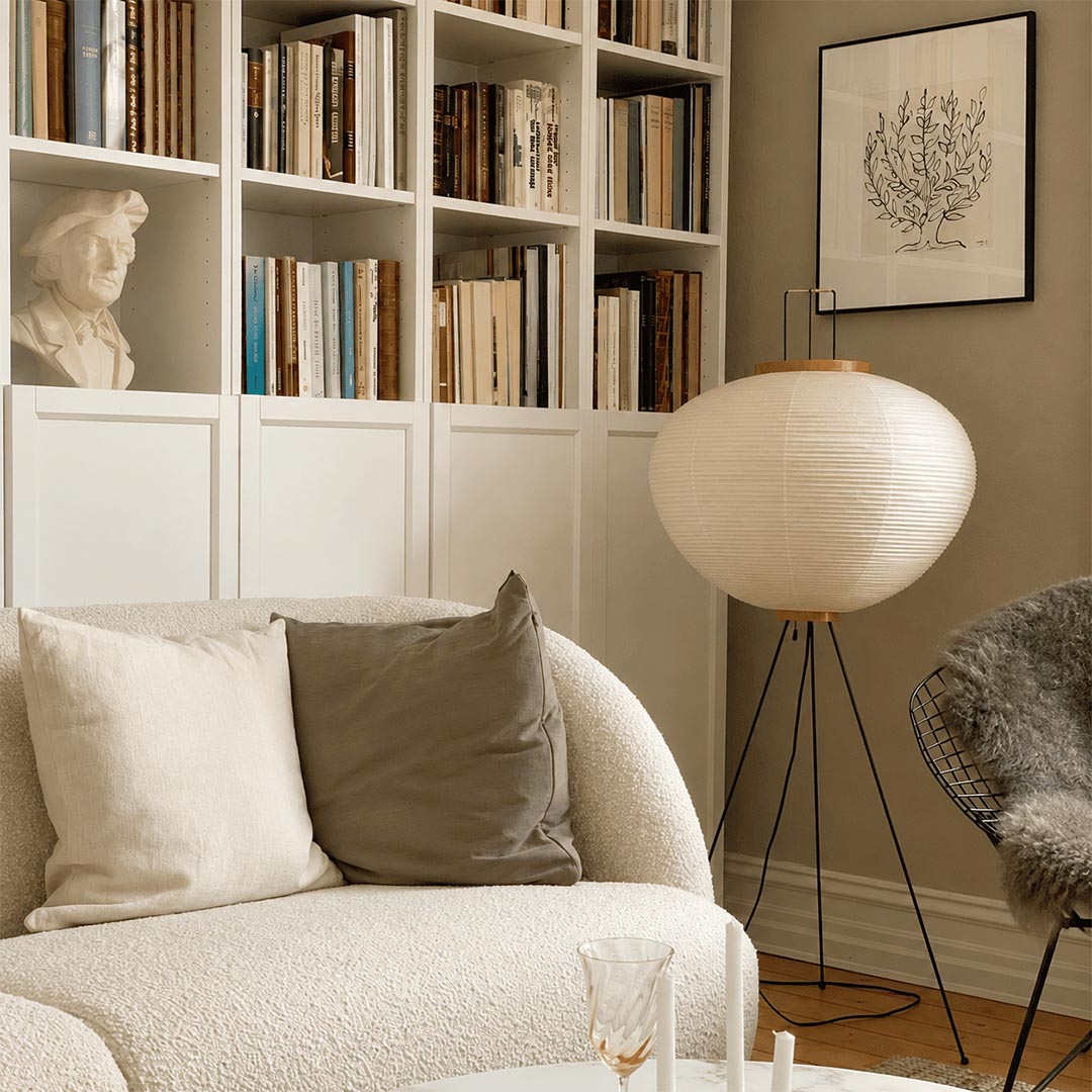 Stuber premium handcrafted off-white washi paper tripod floor lamp with black legs illuminating a modern Japandi living room.