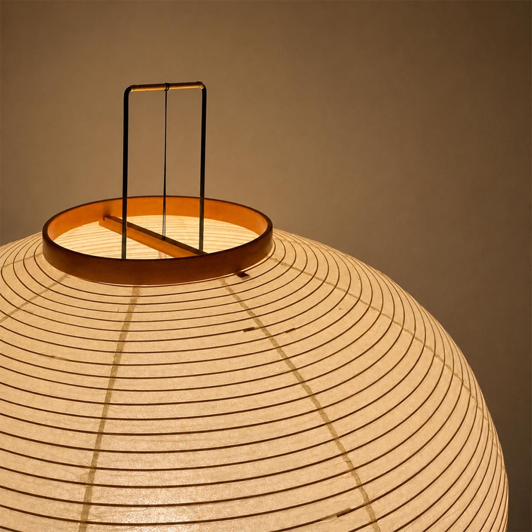 Close-up shot of the top handle bracket on a Stuber Lighting Japanese paper floor lamp, showcasing premium ribbed lantern texture and warm ambient glow.