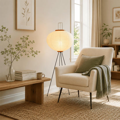 Stuber Lighting Wabi-Sabi style tripod paper floor lamp glowing warmly next to a wooden dining table in a cozy home interior.