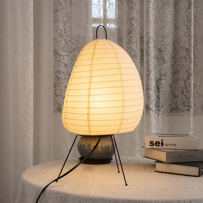 Warm light from Akari 1N paper table lamp on dining table with books - stuberlighting