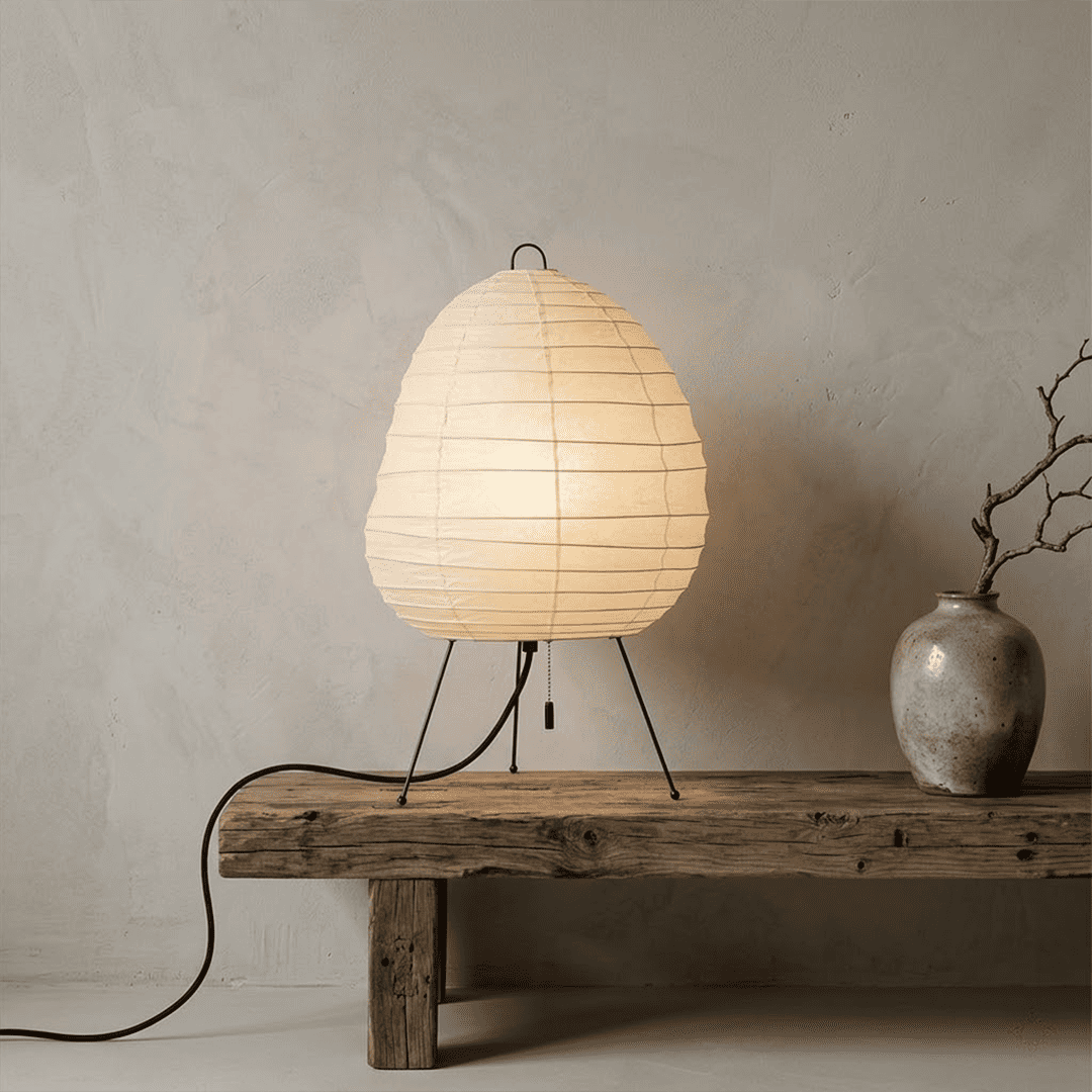 Premium Akari 1N washi paper table lamp emitting a warm glow on a wooden desk.