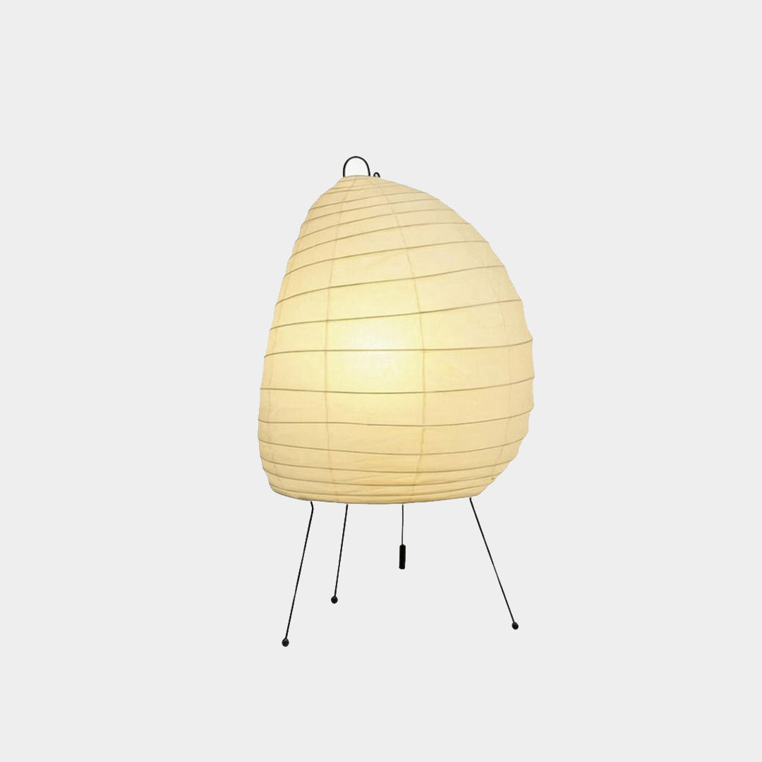 Premium Akari 1N washi paper table lamp emitting a warm glow on a wooden desk.