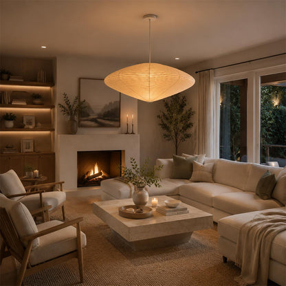 Warmly lit Stuber Lighting oval rice paper pendant lamp centered over a wooden dining table, organic modern interior design and elegant Wabi-Sabi style dining room deco