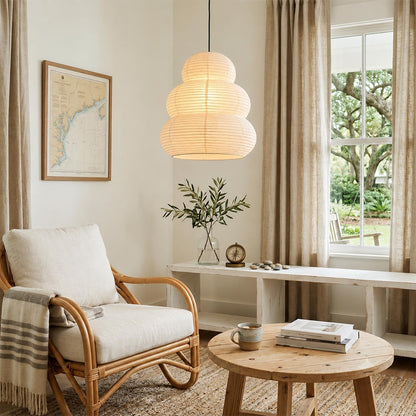 Bright room corner with a rattan armchair and Akari 24N pendant light - Stuber Lighting