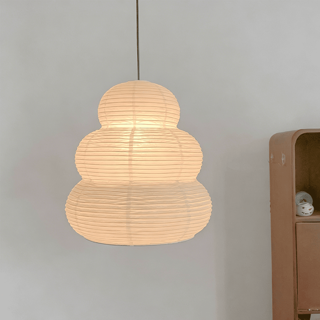 Elegant Akari 24N paper lantern pendant lamp glowing against a clean wall - Stuber Lighting