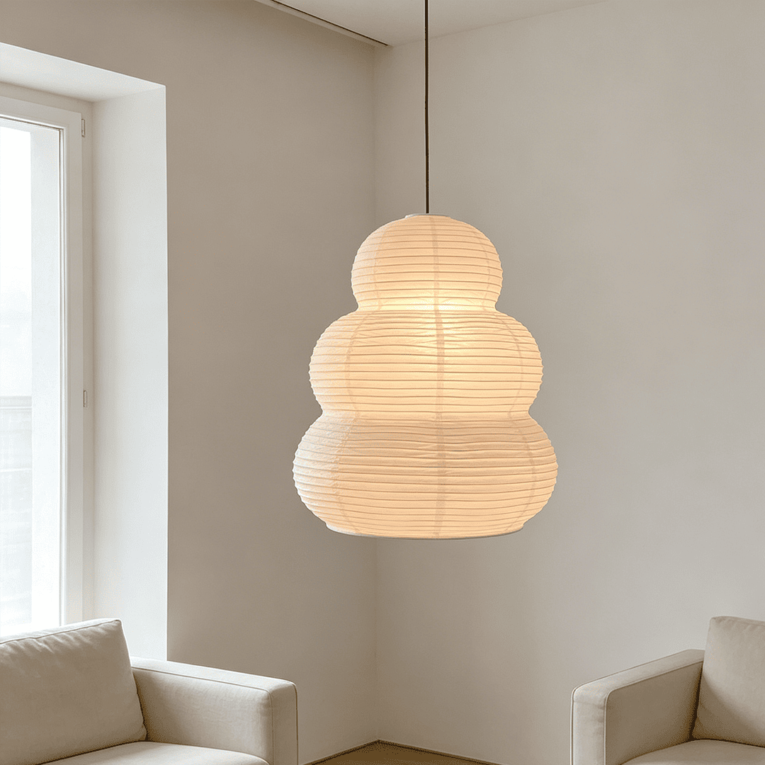 Modern minimalist living room corner with ambient Akari 24N ceiling pendant light - Stuber Lighting