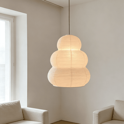 Modern minimalist living room corner with ambient Akari 24N ceiling pendant light - Stuber Lighting
