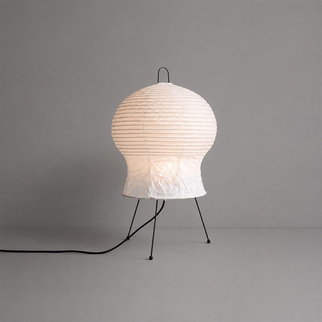 Studio portrait of an Akari 2N Table Lamp illuminated against a clean solid grey background by Stuber Lighting