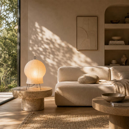 Washi paper Akari 2N Table Lamp casting a soft glow in a sunlit, minimalist neutral-toned living room by Stuber Lighting.