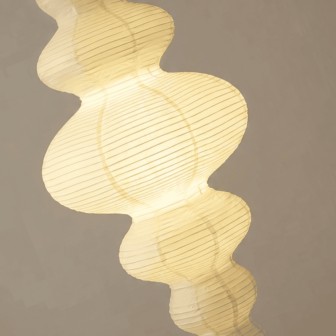 Large Akari Juni washi paper pendant lamp glowing in a minimalist Japandi living room with warm 3000K light.