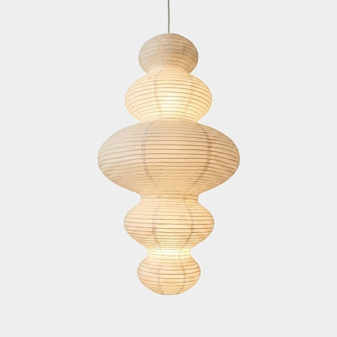 Large Akari Juni washi paper pendant lamp glowing in a minimalist Japandi living room with warm 3000K light.
