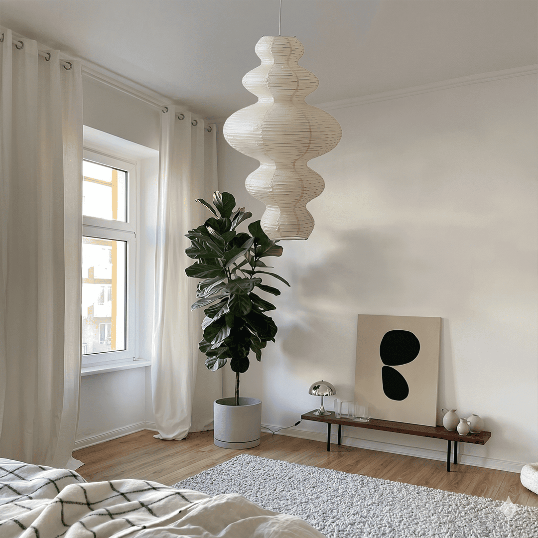 Large Akari Juni washi paper pendant lamp glowing in a minimalist Japandi living room with warm 3000K light.