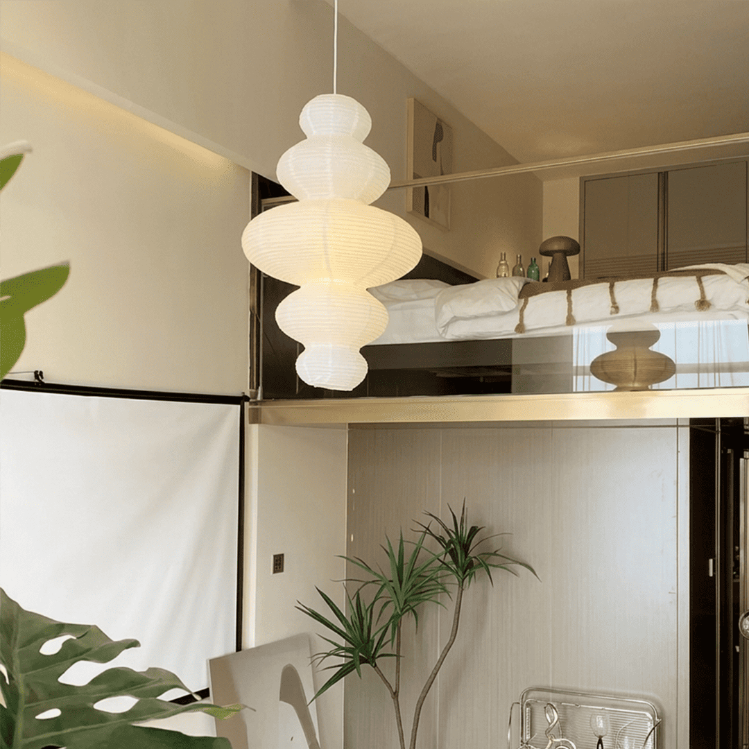 Large Akari Juni washi paper pendant lamp glowing in a minimalist Japandi living room with warm 3000K light.