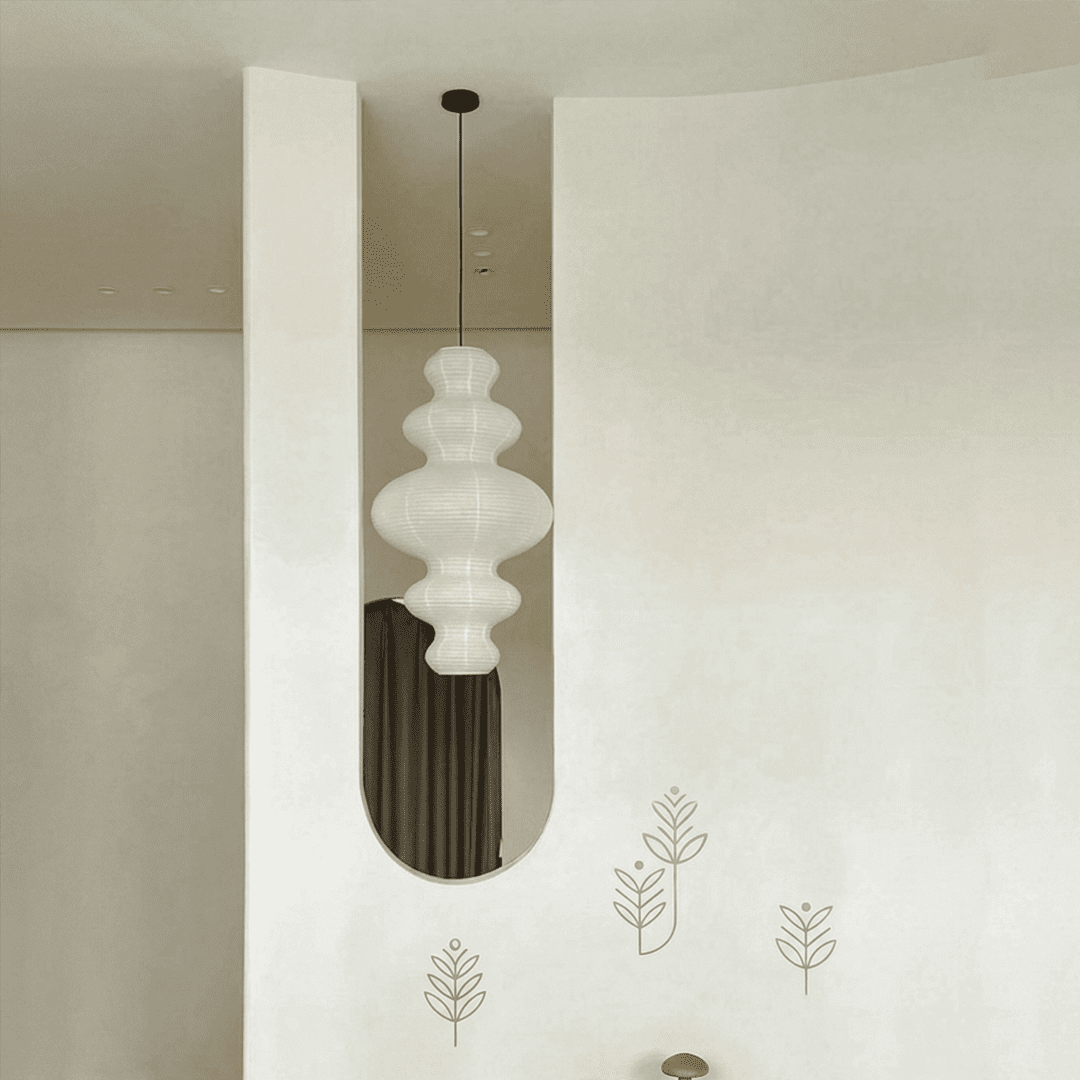 Large Akari Juni washi paper pendant lamp glowing in a minimalist Japandi living room with warm 3000K light.
